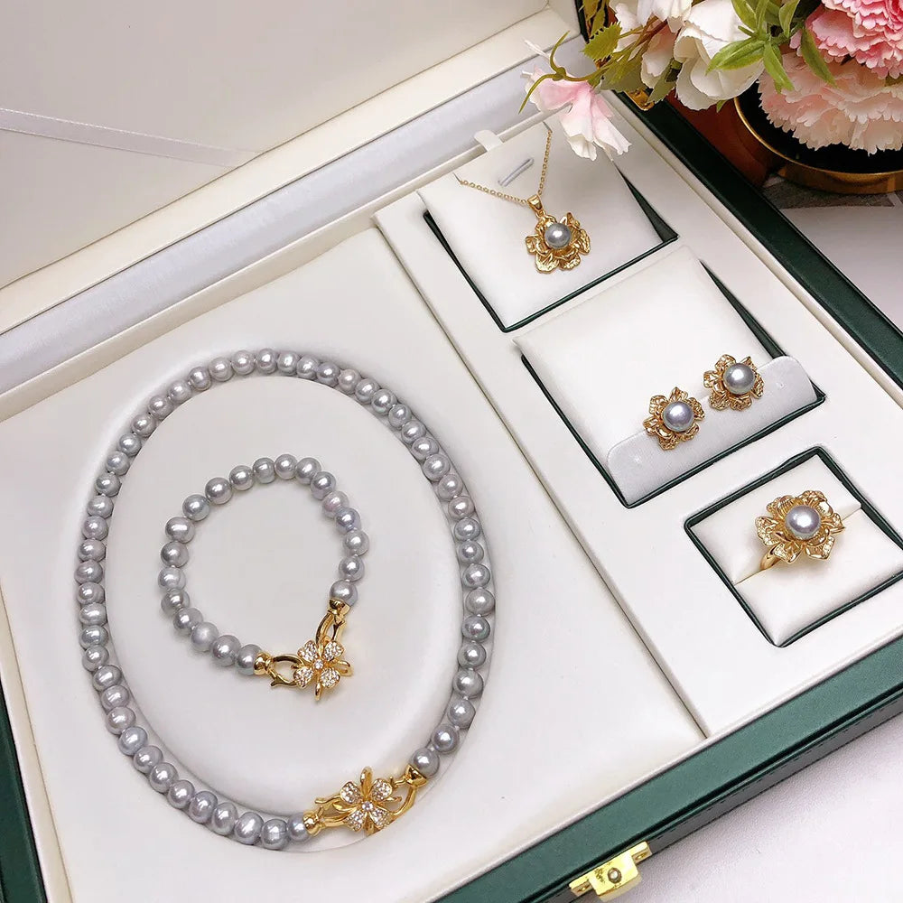 Close-up of grey freshwater pearl earrings with matching necklace and bracelet