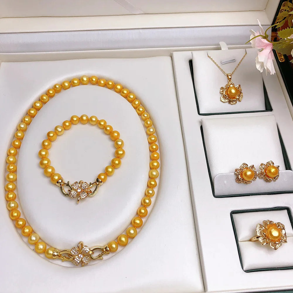 Close-up of yellow freshwater pearl earrings with matching necklace and bracelet